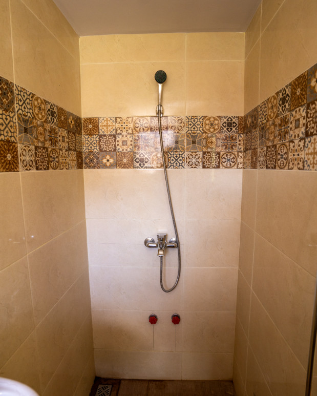 Chambre simple avec douche et toilettes.